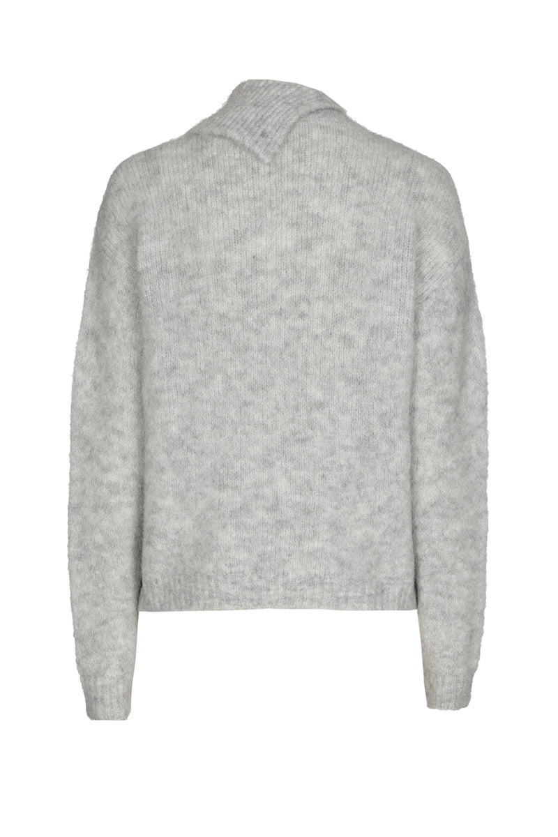 Grijze pull met broche op de opstaande kraag