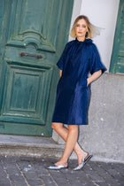 Knielange marineblauwe jurk met strikkraag en ballonmouw