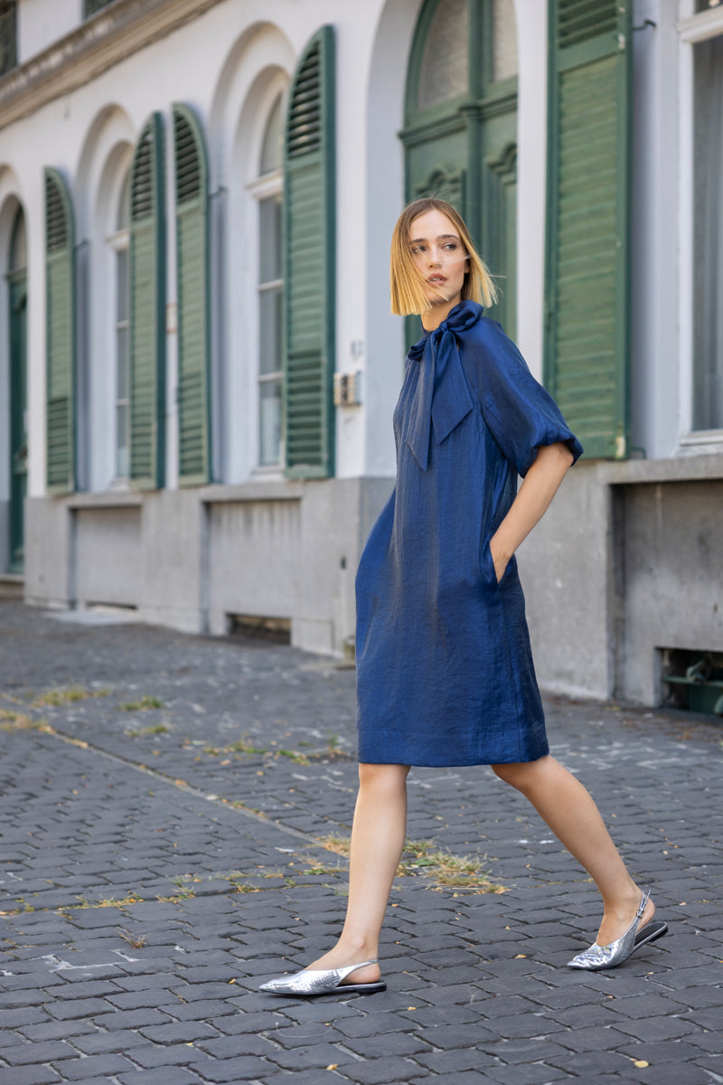Knielange marineblauwe jurk met strikkraag en ballonmouw